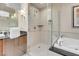 Bright bathroom with a shower featuring glass door, a soaking tub, and a wooden vanity at 145 E Harmon Ave # 2603, Las Vegas, NV 89109