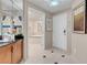 Hallway view, with a doorway to a bathroom with a tub, and white tiled floor with black accent at 145 E Harmon Ave # 2603, Las Vegas, NV 89109