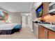 Suite kitchenette with black granite counters, stainless mini-fridge and an entertainment TV at 145 E Harmon Ave # 2603, Las Vegas, NV 89109