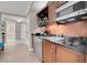 Suite kitchenette features wood cabinets, stainless microwave, mini-fridge, and black granite counters at 145 E Harmon Ave # 2603, Las Vegas, NV 89109