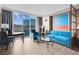 Bright living room featuring stylish blue furniture, artwork, and a large window with city views at 145 E Harmon Ave # 2603, Las Vegas, NV 89109