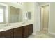 Bright bathroom featuring dual sinks, marble countertops, dark cabinetry, and ensuite access at 1617 Meadow Bluffs Ave, Henderson, NV 89014