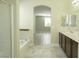 Bathroom featuring dual sinks, a soaking tub, and a separate glass-enclosed shower at 1617 Meadow Bluffs Ave, Henderson, NV 89014