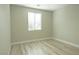 Bright bedroom features wood-look flooring and a sunlit window with modern blinds at 1617 Meadow Bluffs Ave, Henderson, NV 89014