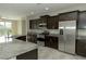 Modern kitchen featuring stainless steel appliances, granite countertops, and dark wood cabinets at 1617 Meadow Bluffs Ave, Henderson, NV 89014