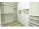 A large walk-in closet with custom white cabinets, drawers, and shelving for ample storage at 1617 Meadow Bluffs Ave, Henderson, NV 89014