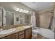 Bathroom featuring double sink vanity with granite counters, framed mirrors, and a tiled shower-tub combo at 2096 Fallsburg Way, Henderson, NV 89002