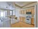 Bright kitchen featuring light wood cabinets, white appliances and tile countertops at 211 Crown Imperial St, Henderson, NV 89074