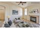 Staged living room featuring a fireplace, ceiling fan, and neutral colored walls at 211 Crown Imperial St, Henderson, NV 89074