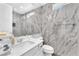 Modern bathroom featuring marble tile, floating vanity, and glass-enclosed shower at 2503 Cracked Stone St, Henderson, NV 89044