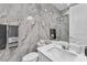 Modern bathroom with marble walls, a large mirror, and a glass-enclosed shower at 2503 Cracked Stone St, Henderson, NV 89044