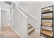 Stairway with light wood floors, white railing, and decorative basket shelving on landing at 2503 Cracked Stone St, Henderson, NV 89044