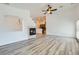 Open-concept living room showcasing fireplace, ceiling fan, and views into kitchen at 2617 Tanagrine Dr, North Las Vegas, NV 89084