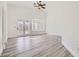 Bright living room with wood-look flooring, ceiling fan, and sliding glass doors to the outside at 2617 Tanagrine Dr, North Las Vegas, NV 89084