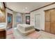 Bright bathroom features a luxurious soaking tub, glass shower and double doors to the backyard at 264 Crestview Dr, Las Vegas, NV 89124