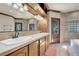 Bathroom with dual sinks, custom cabinetry, a large mirror, and direct access to the yard at 264 Crestview Dr, Las Vegas, NV 89124