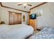 Bedroom features 2 beds, wood trim, ceiling fan, and large dresser with TV at 264 Crestview Dr, Las Vegas, NV 89124