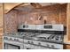 Gourmet kitchen features a professional grade gas range with double ovens, set in a stone tile backsplash at 264 Crestview Dr, Las Vegas, NV 89124