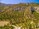 Mountainside covered in green trees and winding roads on a clear day at 264 Crestview Dr, Las Vegas, NV 89124