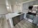 Updated kitchen features stainless appliances, grey cabinets, and peninsula with bar seating at 2964 Juniper Hills Blvd # 202, Las Vegas, NV 89142