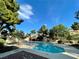 Sparkling community pool surrounded by mature trees at 2964 Juniper Hills Blvd # 202, Las Vegas, NV 89142