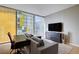 Modern living room featuring a gray sofa, desk, TV, and large windows offering ample natural light at 3722 Las Vegas Blvd # 1609, Las Vegas, NV 89158