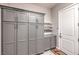 Bright laundry room with ample gray cabinet space, countertop, open shelving, and a white door at 415 Point Sur Ave, Las Vegas, NV 89138