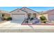 Well-maintained single-story home with desert landscaping, two-car garage, and sidewalk access at 473 Elm Crest Pl, Henderson, NV 89012