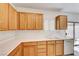 Practical kitchen with wooden cabinets, white countertops, and a sliding glass door at 473 Elm Crest Pl, Henderson, NV 89012