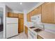 Functional kitchen with wood cabinets, white appliances, and ample counter space at 473 Elm Crest Pl, Henderson, NV 89012