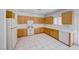 Well-lit kitchen featuring white appliances, wood cabinets, and tile flooring at 473 Elm Crest Pl, Henderson, NV 89012