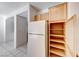 Spacious kitchen with tile floor, white refrigerator, and pantry with wooden shelves at 473 Elm Crest Pl, Henderson, NV 89012