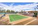 Brightly lit tennis court with covered seating area and lush landscaping, ideal for active residents at 473 Elm Crest Pl, Henderson, NV 89012