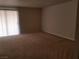 Spacious living room featuring carpet flooring and a sliding glass door for ample sunlight at 4965 Indian River Dr # 108, Las Vegas, NV 89103