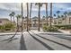 Laguna Del Rey Community Clubhouse entrance flanked by mature palm trees and lush garden landscaping at 5000 Red Rock St # 105, Las Vegas, NV 89118