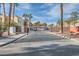 Laguna Del Rey entrance gate and grounds featuring mature landscaping, block walls, and security features at 5000 Red Rock St # 105, Las Vegas, NV 89118