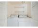 Convenient laundry room featuring a full-size washer, dryer, and overhead shelving at 5000 Red Rock St # 105, Las Vegas, NV 89118