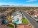 This aerial view showcases a charming home with a private pool, solar panels, and mountain views at 5009 Rustic Charm Ct, Las Vegas, NV 89131