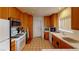Traditional kitchen with wooden cabinets, tile flooring, ample counter space, and essential appliances at 5449 Bugle Way # 102, Las Vegas, NV 89108