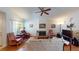 Bright living room featuring hardwood floors, cozy seating, fireplace, ceiling fan, and natural light at 5449 Bugle Way # 102, Las Vegas, NV 89108