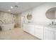 Modern bathroom featuring a luxurious standalone tub, white cabinets, and dual sinks under recessed lighting at 714 Lacy Ln, Las Vegas, NV 89107
