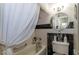 Bathroom with white and black tile, white curtain, a round mirror, and modern fixtures at 730 S Royal Crest Cir # 424, Las Vegas, NV 89169