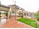 A shot of the rear of the home exhibiting a well-kept yard featuring artificial turf, an outdoor pool, and mature trees at 7565 N Torrey Pines Dr # A, Las Vegas, NV 89131