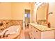Bright bathroom featuring a tub, tiled walls, and a vanity with granite countertops at 7565 N Torrey Pines Dr # A, Las Vegas, NV 89131