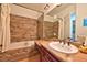 Bathroom featuring a wood-look tiled shower, vanity, and modern lighting at 7565 N Torrey Pines Dr # A, Las Vegas, NV 89131