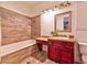 Bathroom featuring a wood-look tiled shower, vanity, and decorative elements at 7565 N Torrey Pines Dr # A, Las Vegas, NV 89131