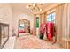 An elegant dressing room with a marble fireplace, chandelier, and designer clothing rack at 7565 N Torrey Pines Dr # A, Las Vegas, NV 89131