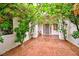 Charming entrance featuring a covered walkway with lush greenery, leading to a grey front door at 7565 N Torrey Pines Dr # A, Las Vegas, NV 89131
