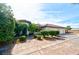 Desert home featuring a spacious driveway, well manicured landscaping, and a red tile roof at 7565 N Torrey Pines Dr # A, Las Vegas, NV 89131