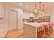 Bright kitchen features white cabinets, marble counters, and large island with chairs at 7565 N Torrey Pines Dr # A, Las Vegas, NV 89131